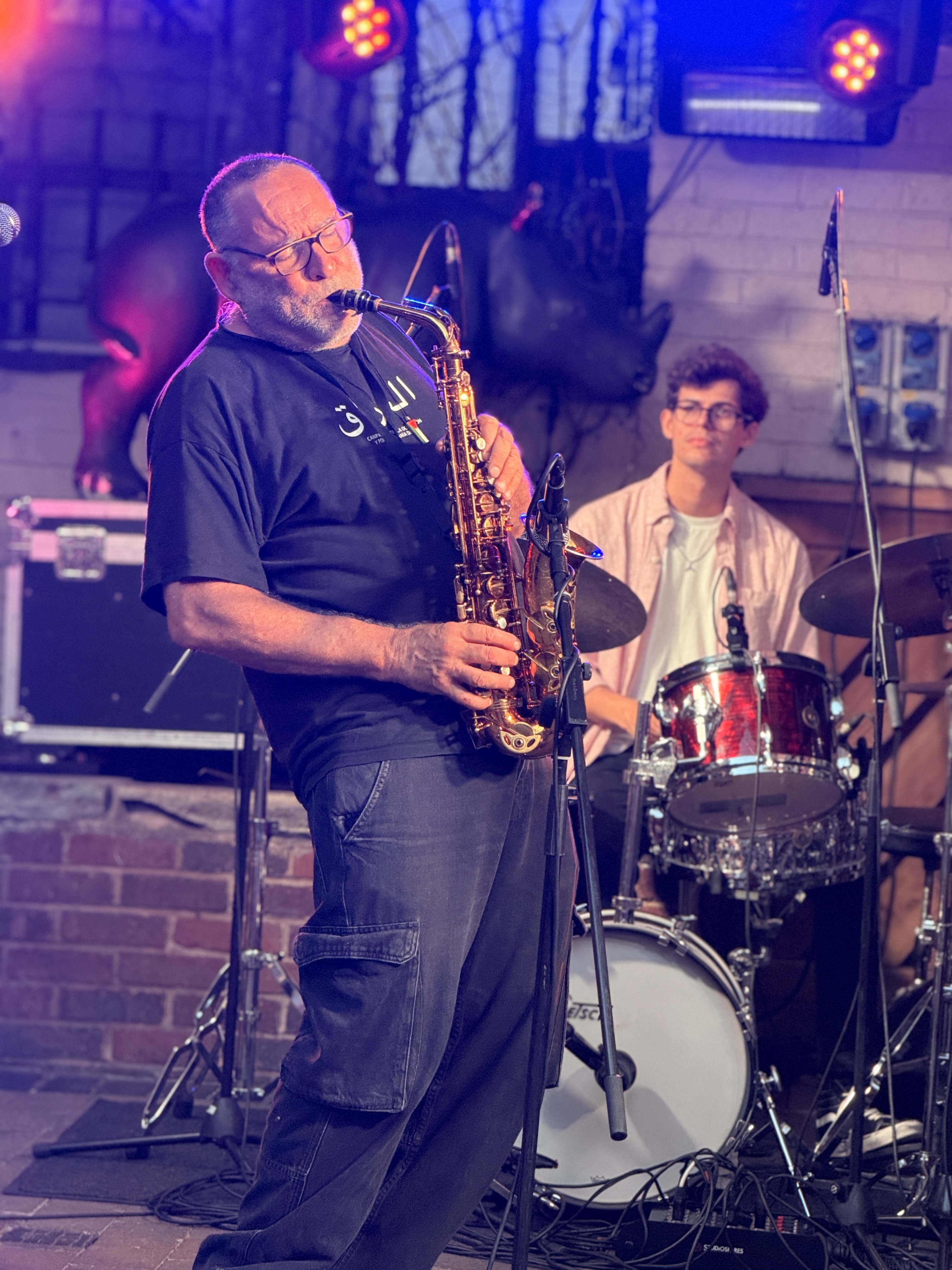 Live saxophone performance in Rufus Court at night